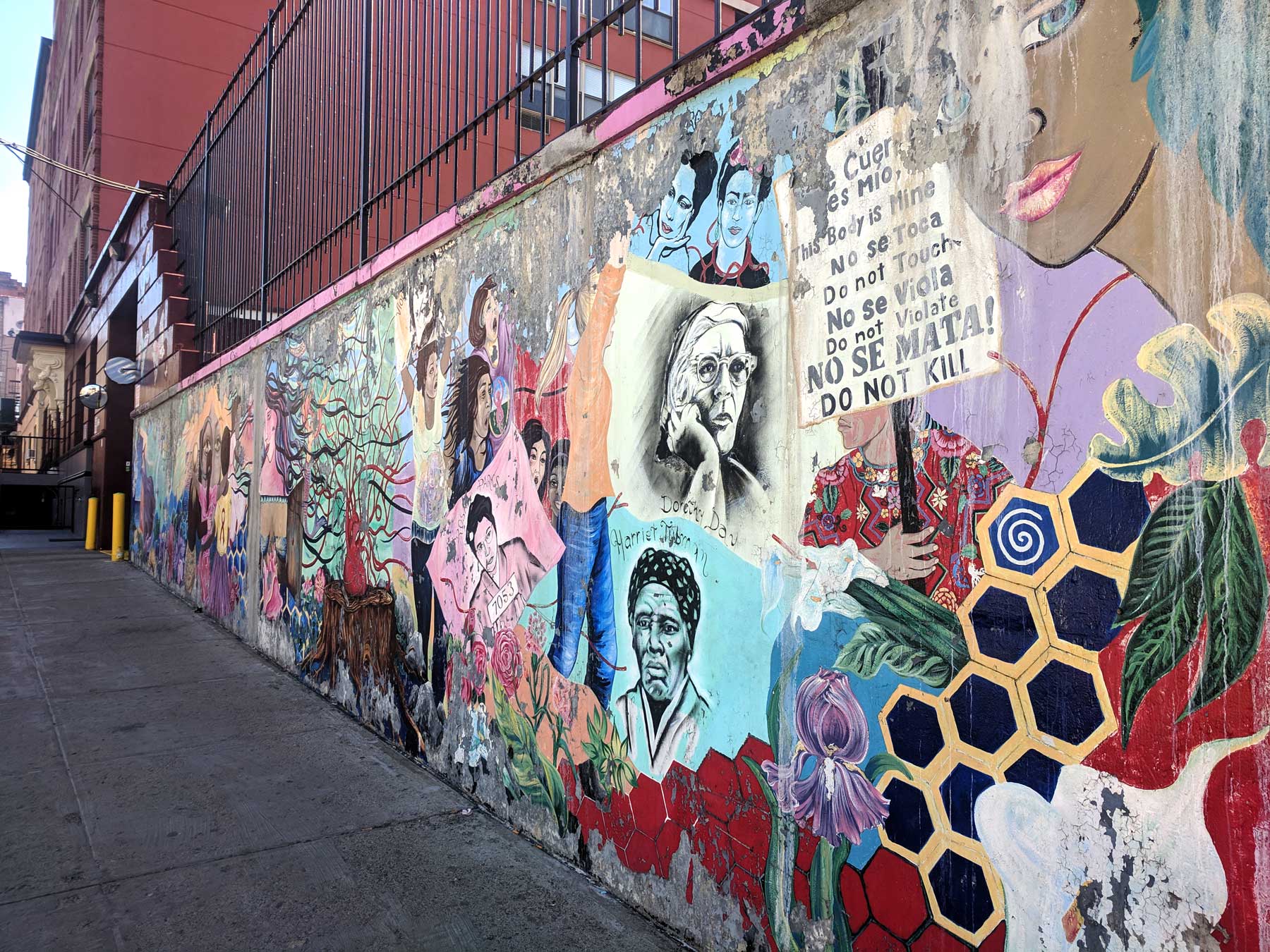 A mural of historical figures along a city street.