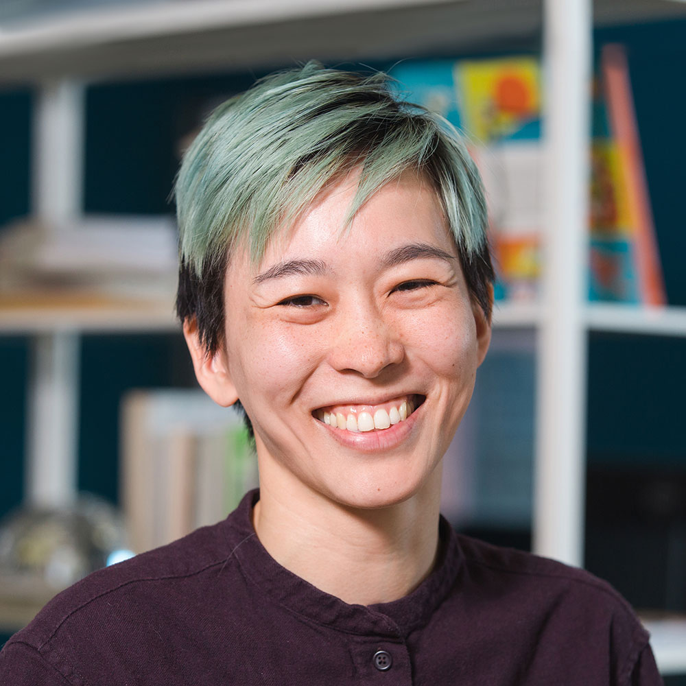 Headshot of Stephanie Yim smiling in front of a bookshelf.