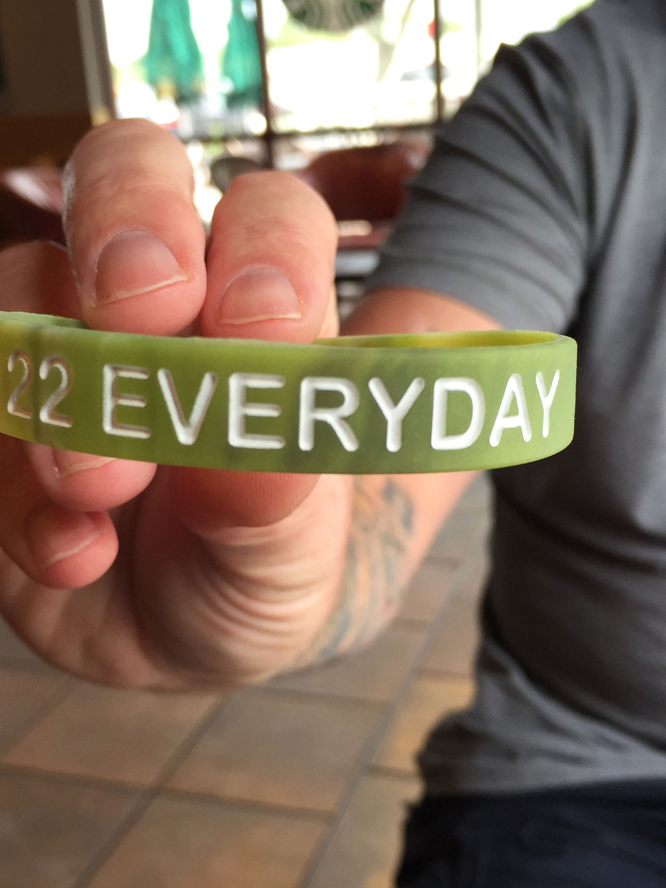 A hand holding up a bracelet that reads "22 Everyday"