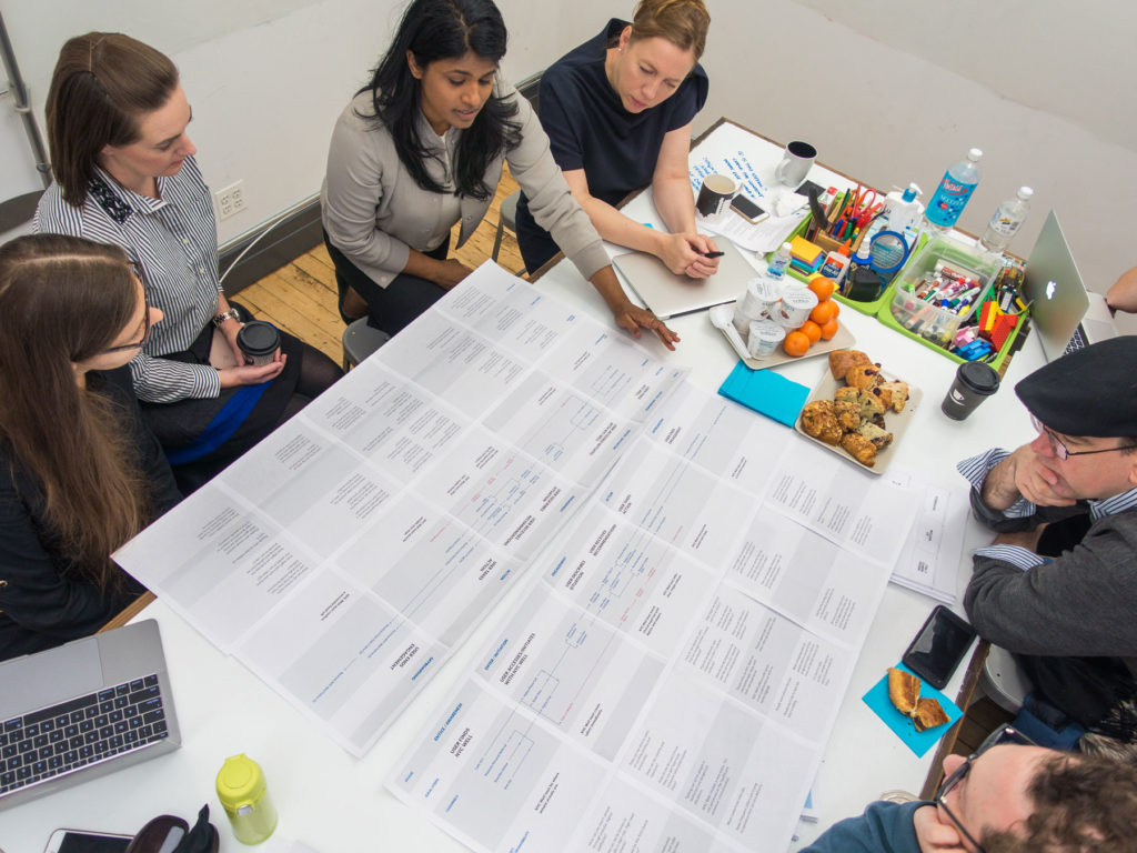 A group of PPL team members gather around a large table