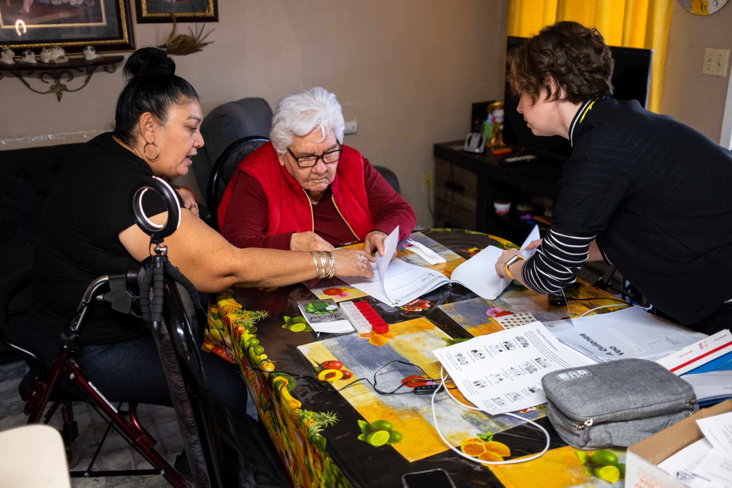 A researcher from the Public Policy Lab provides materials to an older adult and their caregiver.